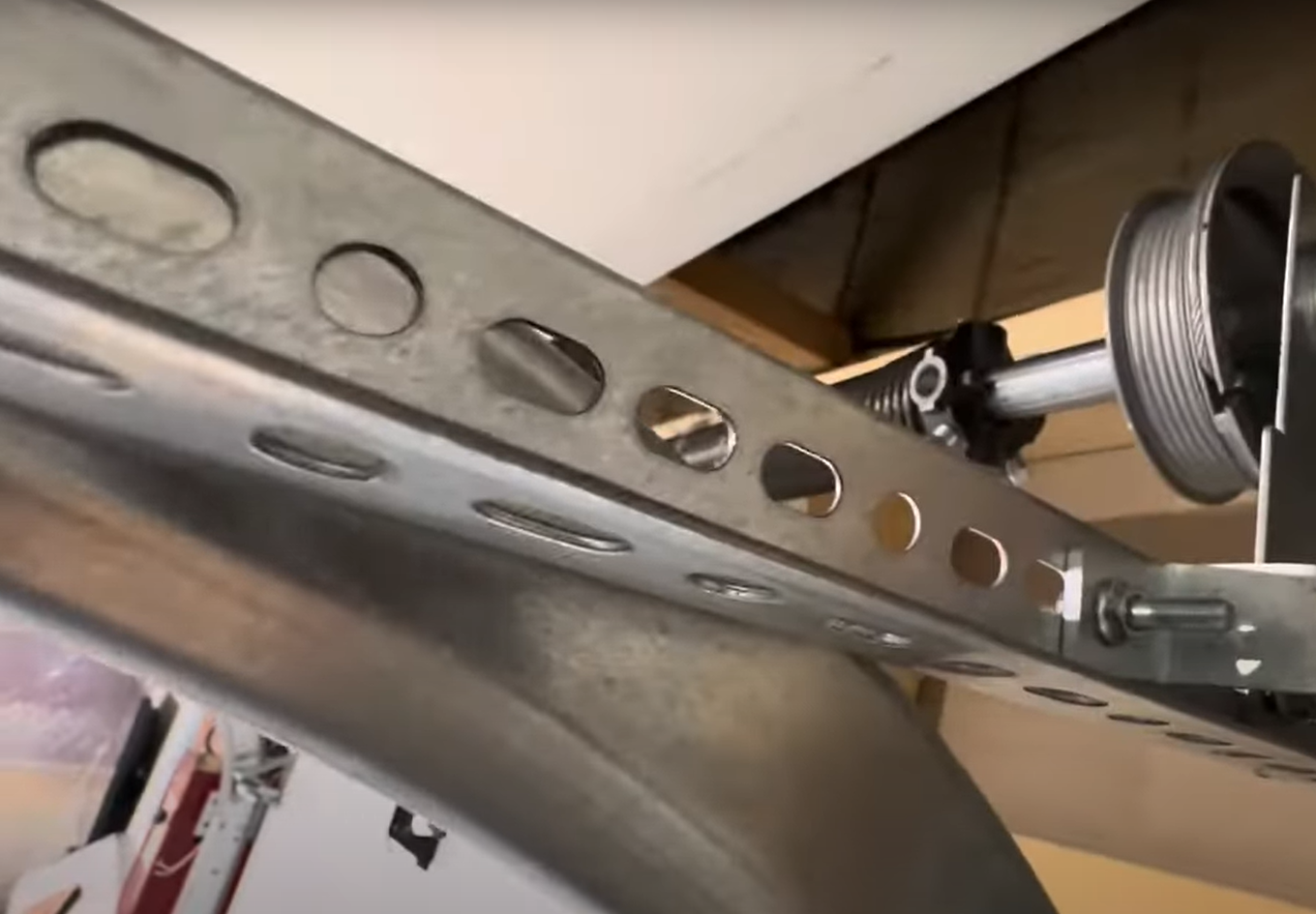 Close-up of a technician performing garage door track repair, aligning and adjusting the track for smooth operation.