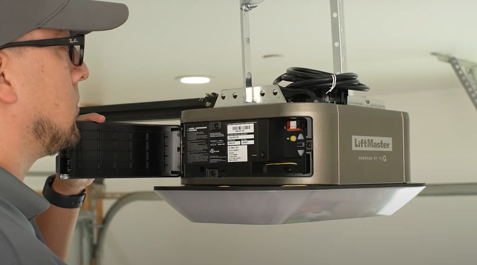 A professional technician fixing a garage door opener, showcasing the expertise of Mariner Garage Door Repair in efficient garage door opener repair services.